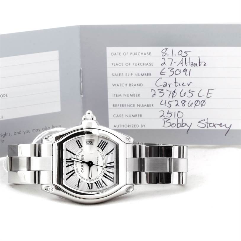 The image shows a Cartier Roadster W62025V3 Men
s Stainless Steel Silver Dial W62025V3 Men
s Stainless Steel Silver Dial watch from the front angle with its metal bracelet and warranty card.
