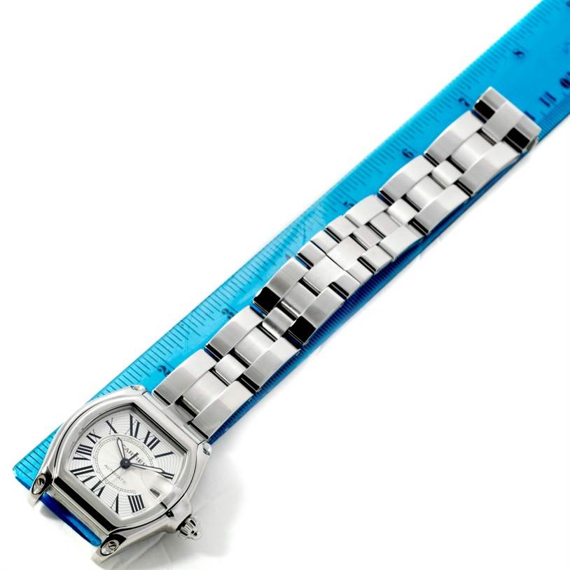 The image shows a Cartier Roadster W62025V3 Men's Stainless Steel Silver Dial W62025V3 Men's Stainless Steel Silver Dial watch, featuring its full bracelet and face, laid flat against a ruler.