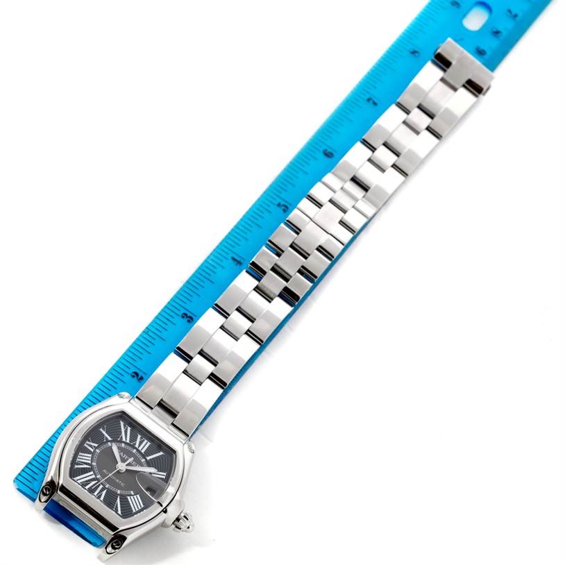 The image shows a Cartier Roadster W62041V3 Men's Stainless Steel Black Dial W62041V3 Men's Stainless Steel Black Dial watch laid flat with a ruler for scale, featuring the face and full bracelet.