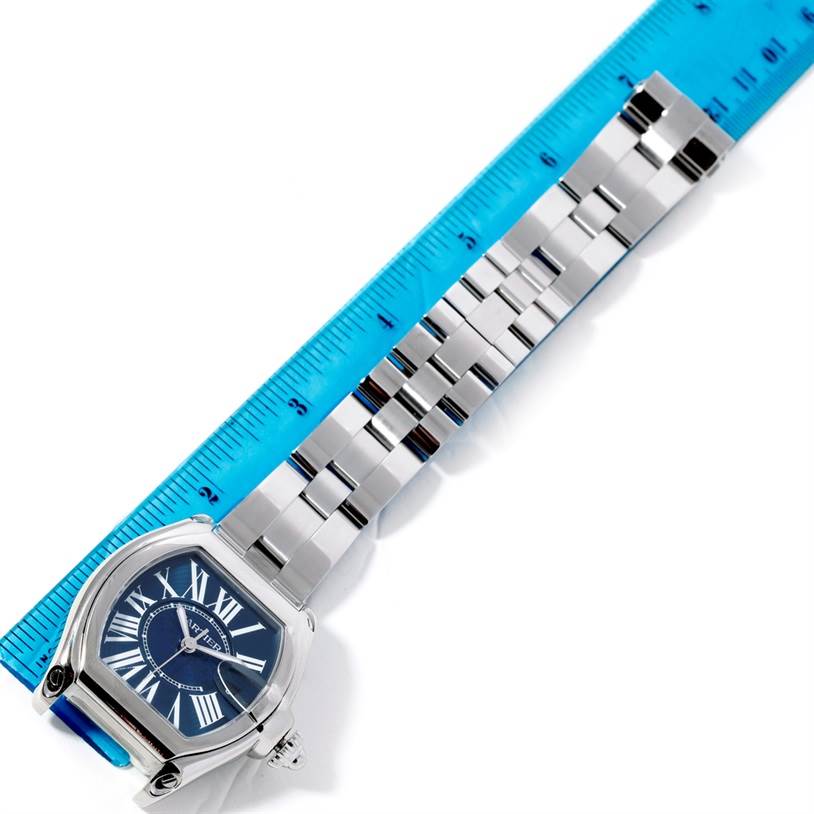 The image shows a Cartier Roadster W6206012 Men's Stainless Steel Blue Dial W6206012 Men's Stainless Steel Blue Dial watch face and bracelet laid next to a blue ruler for measurement.