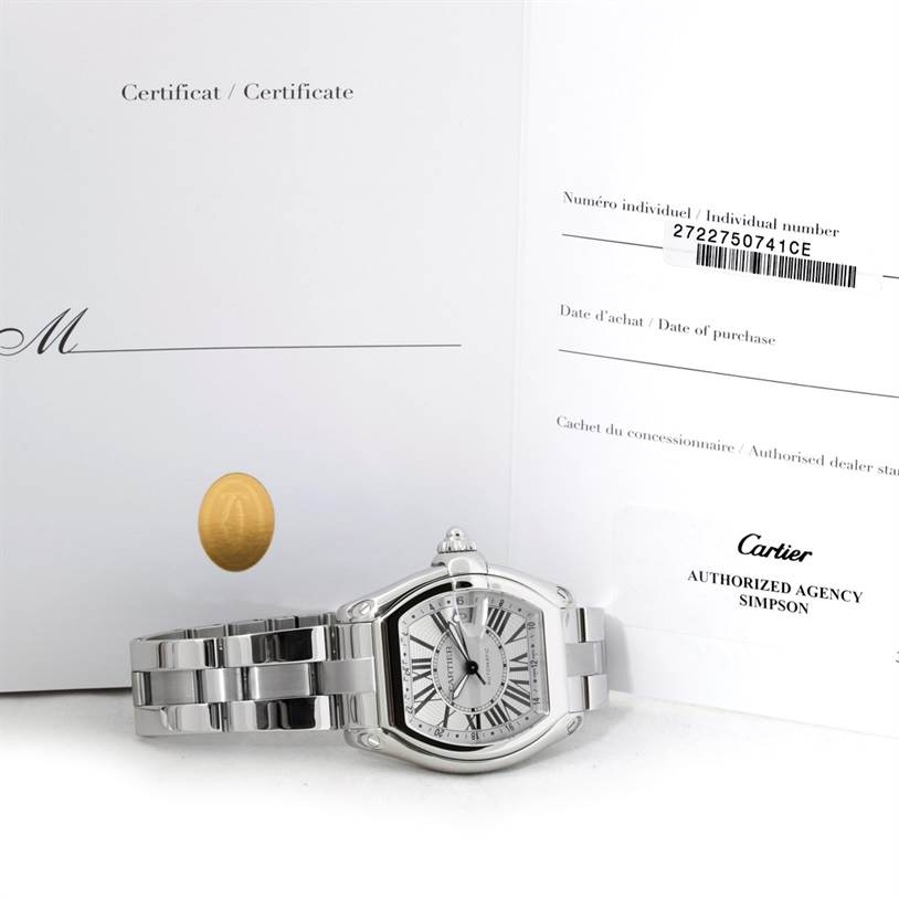 The image shows a Cartier Roadster W62032X6 Men's Stainless Steel Silver Dial W62032X6 Men's Stainless Steel Silver Dial watch laying flat with its certificate and purchase documents in the background.