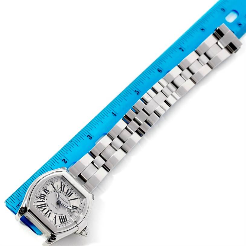 The image shows a Cartier Roadster W62032X6 Men's Stainless Steel Silver Dial W62032X6 Men's Stainless Steel Silver Dial watch laid flat next to a ruler, highlighting its bracelet and face.
