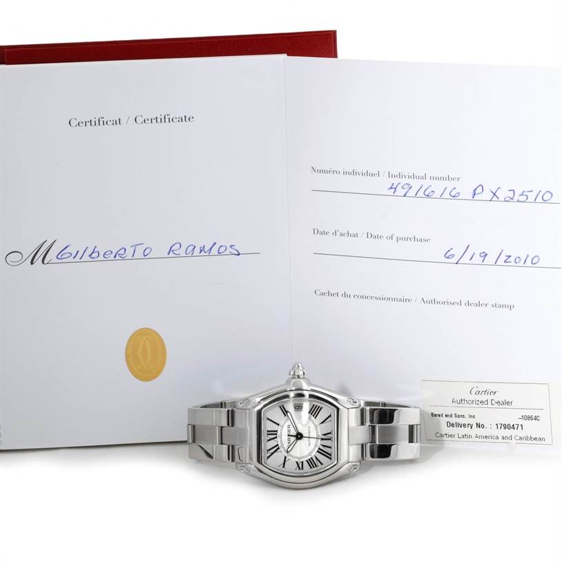 The image shows a Cartier Roadster W62025V3 Men's Stainless Steel Silver Dial W62025V3 Men's Stainless Steel Silver Dial watch and its certificate, laid flat with a frontal view of the watch.