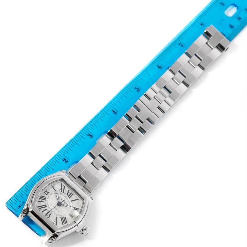 The image shows a Cartier Roadster W62025V3 Men's Stainless Steel Silver Dial W62025V3 Men's Stainless Steel Silver Dial watch, including its face and stainless steel bracelet, measured next to a blue ruler.