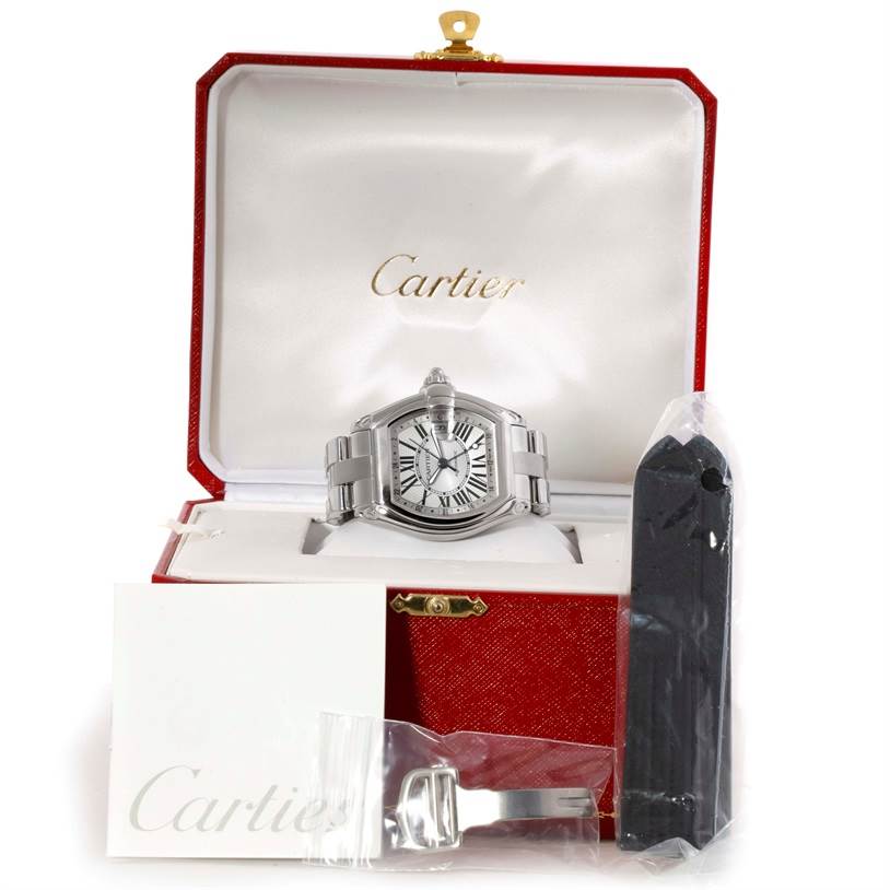The image shows a Cartier Roadster W62032X6 Men's Stainless Steel Silver Dial W62032X6 Men's Stainless Steel Silver Dial watch in its open case, along with additional straps and a buckle accessory.