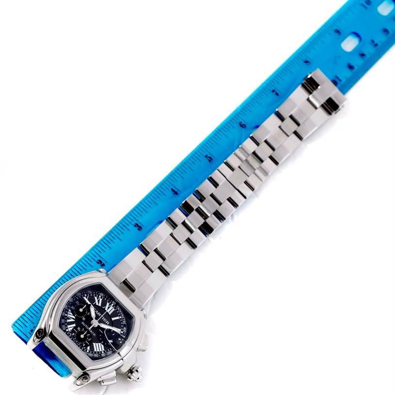 This image shows the dial and metal bracelet of the Cartier Roadster W62007X6 Men's Stainless Steel Black Dial W62007X6 Men's Stainless Steel Black Dial watch lying next to a ruler for measurement.