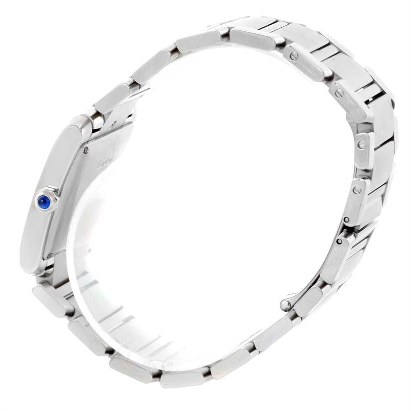 The Cartier Tank Française watch is shown from a side view, highlighting its metal bracelet and crown with a blue cabochon.