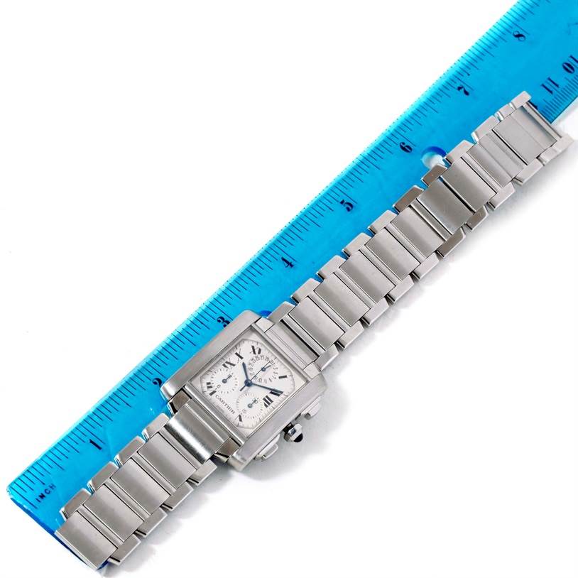 The Cartier Tank Francaise W51001Q3 Men
s Stainless Steel White Dial W51001Q3 Men
s Stainless Steel White Dial watch is shown from above, displaying its bracelet and square face next to a blue ruler.