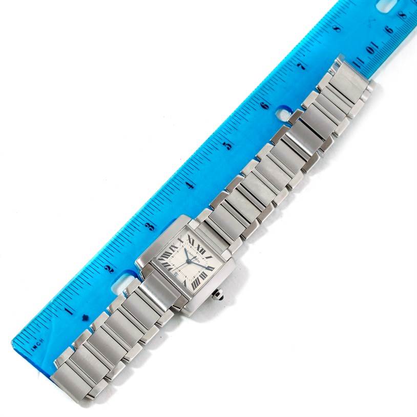 The image shows a full view of a Cartier Tank Francaise W51002Q3 Men's Stainless Steel Silver Dial W51002Q3 Men's Stainless Steel Silver Dial watch, laying flat next to a blue ruler.