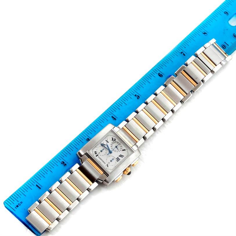 The Cartier Tank Francaise W51004Q4 Men
s Steel and Gold (two tone) Silver Dial W51004Q4 Men
s Steel and Gold (two tone) Silver Dial watch is shown from a top view, next to a blue ruler, displaying its face and metal bracelet.