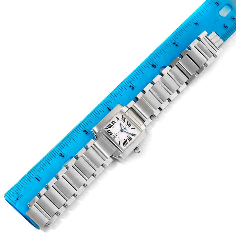 The Cartier Tank Française watch is shown from an aerial view alongside a blue ruler for scale.