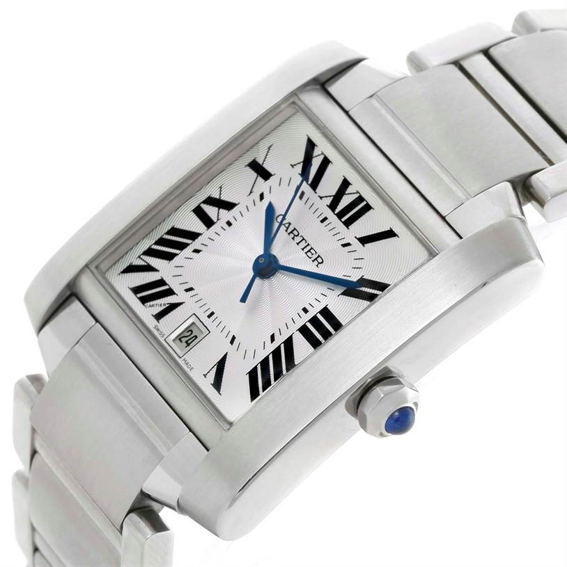 The Cartier Tank Française watch is shown at an angle displaying the face, bezel, bracelet, and crown with a blue cabochon.