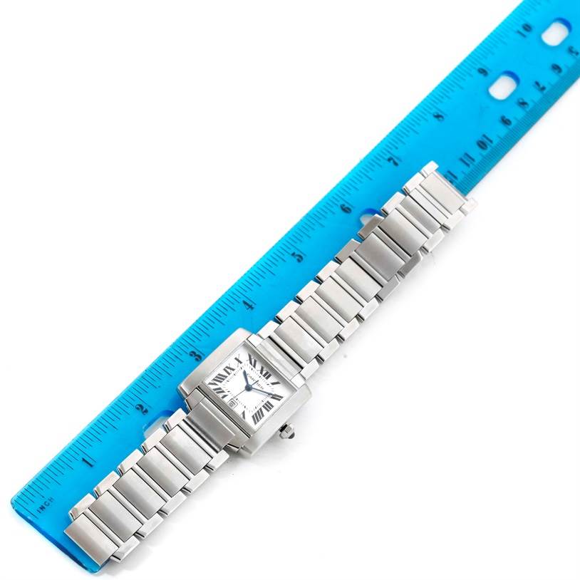 The Cartier Tank Francaise W51002Q3 Men
s Stainless Steel Silver Dial W51002Q3 Men
s Stainless Steel Silver Dial watch is shown from a top-down angle, lying next to a blue ruler displaying its length.