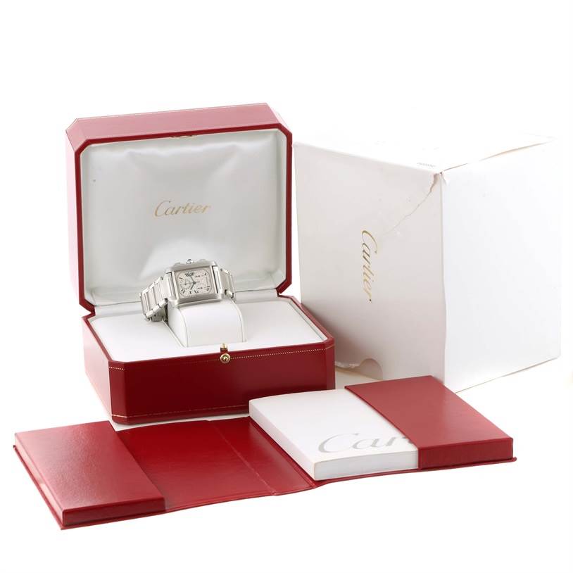 The Cartier Tank Francaise W51001Q3 Men's Stainless Steel White Dial W51001Q3 Men's Stainless Steel White Dial watch is shown at an angle inside its red and white box, accompanied by a white outer box and red booklets.