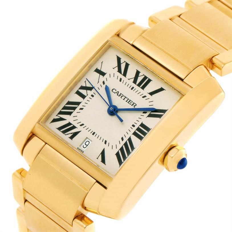 The Cartier Tank Francaise W50001R2 Men's Yellow Gold Silver Dial W50001R2 Men's Yellow Gold Silver Dial watch is shown at a tilted angle, highlighting its gold case, bracelet, and rectangular dial with Roman numerals.