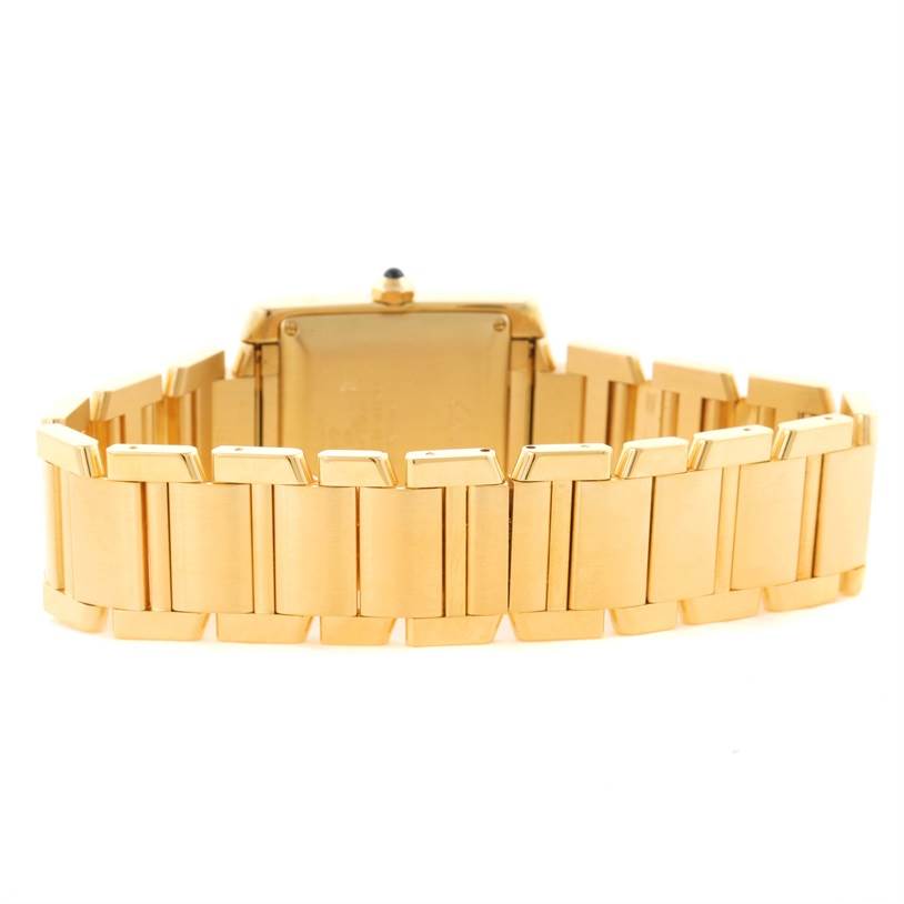 The image shows the back view of a Cartier Tank Française model watch, focusing on the gold bracelet and case back.