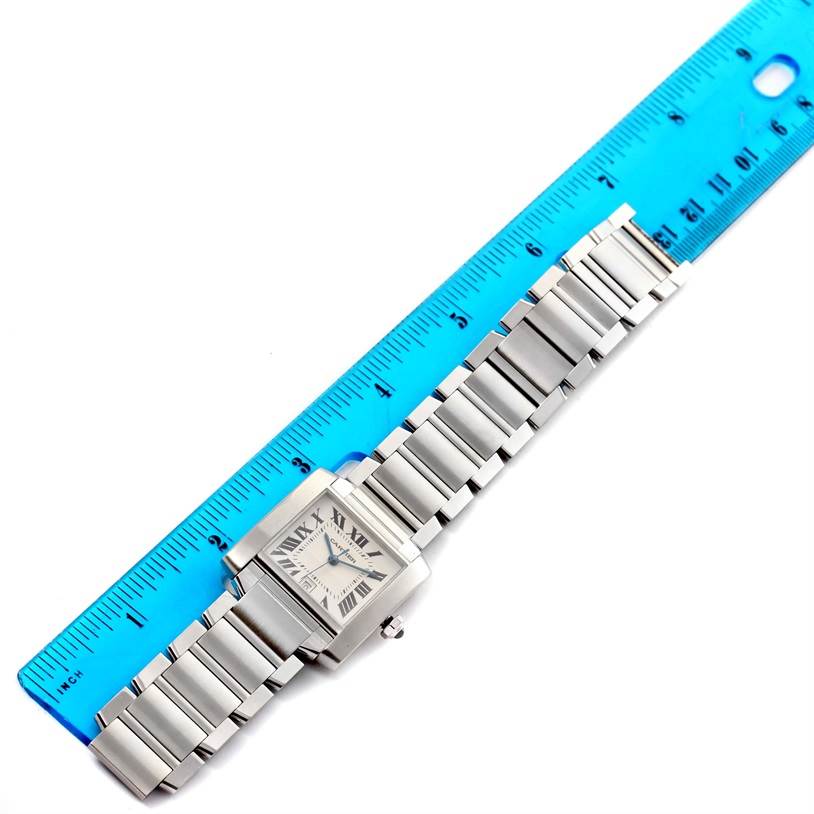 The Cartier Tank Francaise Stainless Steel Silver Dial Stainless Steel Silver Dial watch is shown from a top-down angle, aligned next to a blue ruler.