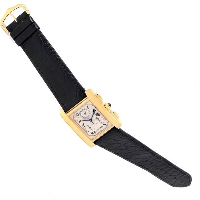 The image shows a Cartier Tank Française watch, taken from a top-down angle, featuring its rectangular face, black strap, and gold casing.