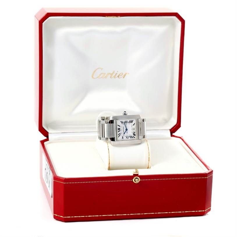 The image shows a Tank Française watch by Cartier, front view, resting in its open red and white case.