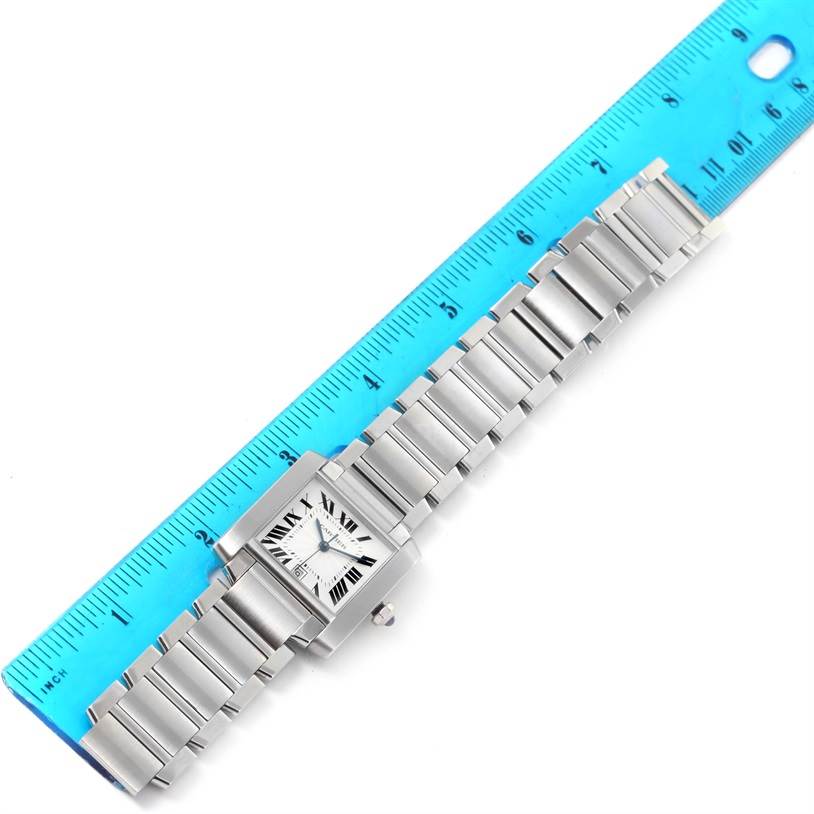 The photo shows a top view of the Cartier Tank Francaise W51002Q3 Men
s Stainless Steel Silver Dial W51002Q3 Men
s Stainless Steel Silver Dial watch, including its face and metal bracelet, against a blue ruler for scale.