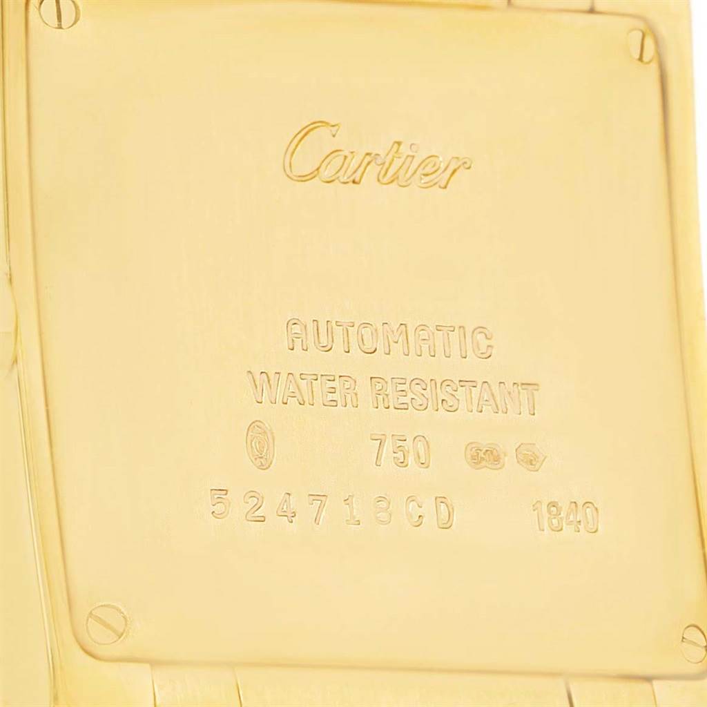 The image shows the backside of a Cartier Tank Francaise W50001R2 Yellow Gold Silver Dial W50001R2 Yellow Gold Silver Dial watch, detailing its engravings and gold material.