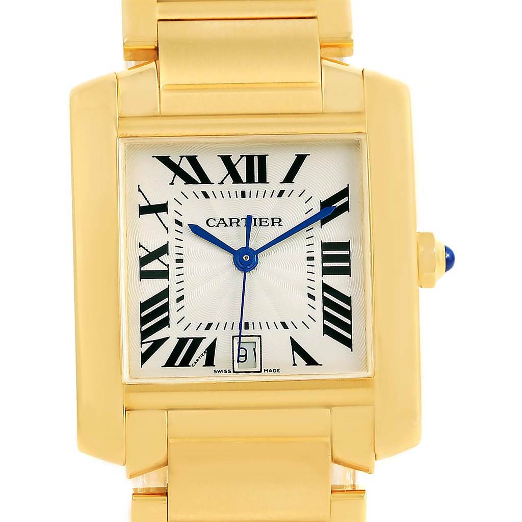 The image shows a close-up view of the Cartier Tank Francaise W50001R2 Yellow Gold Silver Dial W50001R2 Yellow Gold Silver Dial watch, highlighting its gold case, Roman numeral dial, and blue hands.
