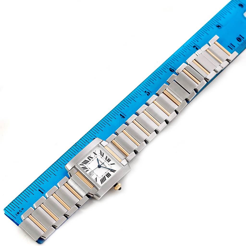 The image shows a Cartier Tank Francaise W51005Q4 Men's Steel and Gold (two tone) Silver Dial W51005Q4 Men's Steel and Gold (two tone) Silver Dial watch, featuring its face, bracelet, and a ruler for scale.