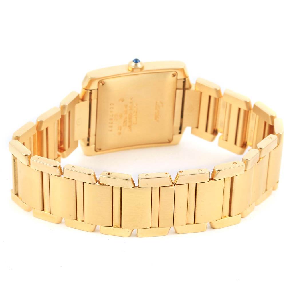 This Tank Française watch by Cartier is shown from the back, displaying its gold rectangular case and bracelet.
