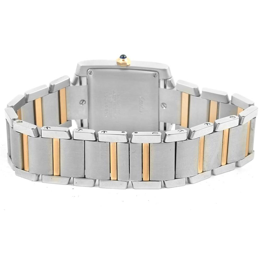 The image shows the back view of a Cartier Tank Française watch, focusing on the case back and two-tone bracelet.