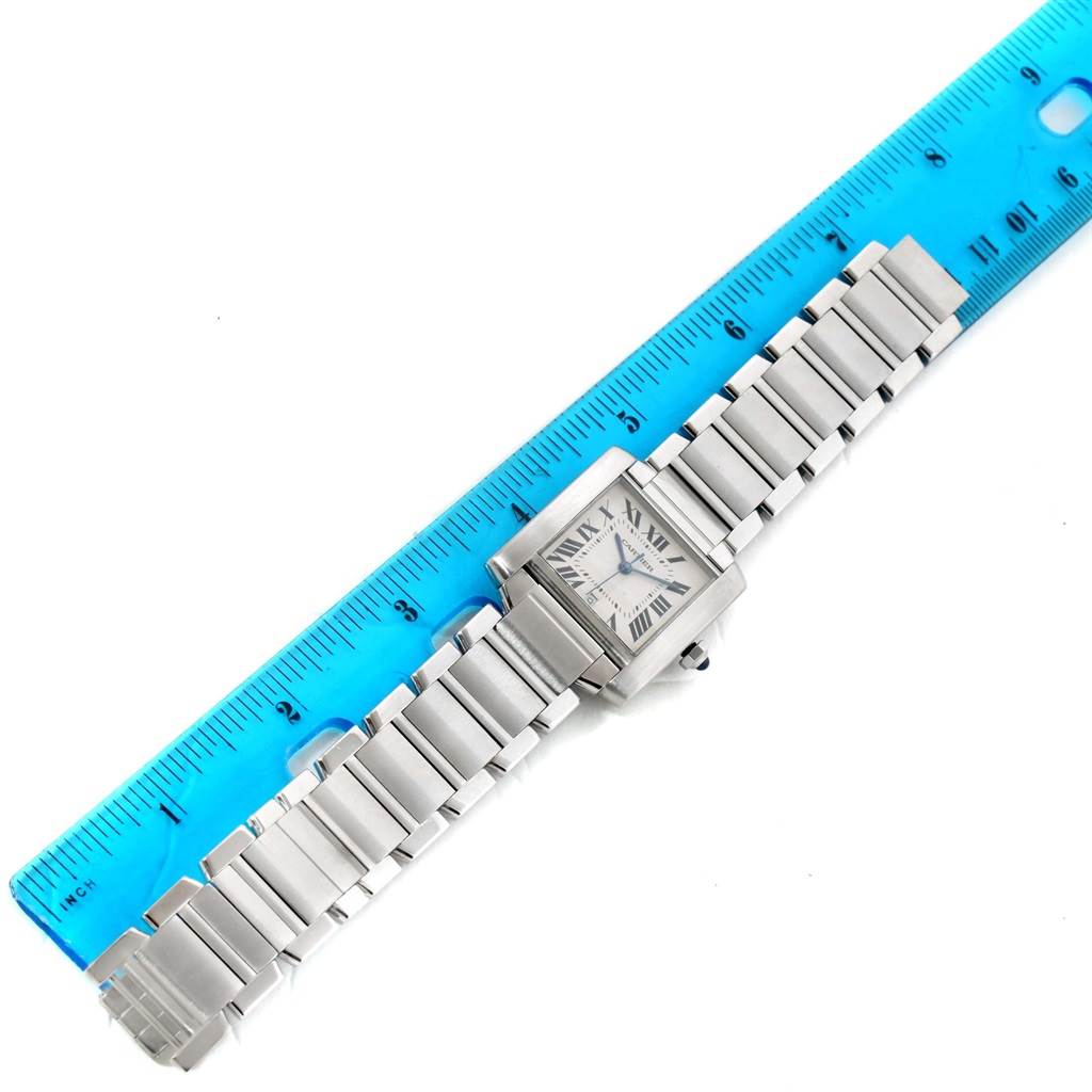 The Cartier Tank Francaise W51002Q3 Stainless Steel Silver Dial W51002Q3 Stainless Steel Silver Dial watch is shown from a top-down angle, displaying the full bracelet and face next to a blue ruler for scale.