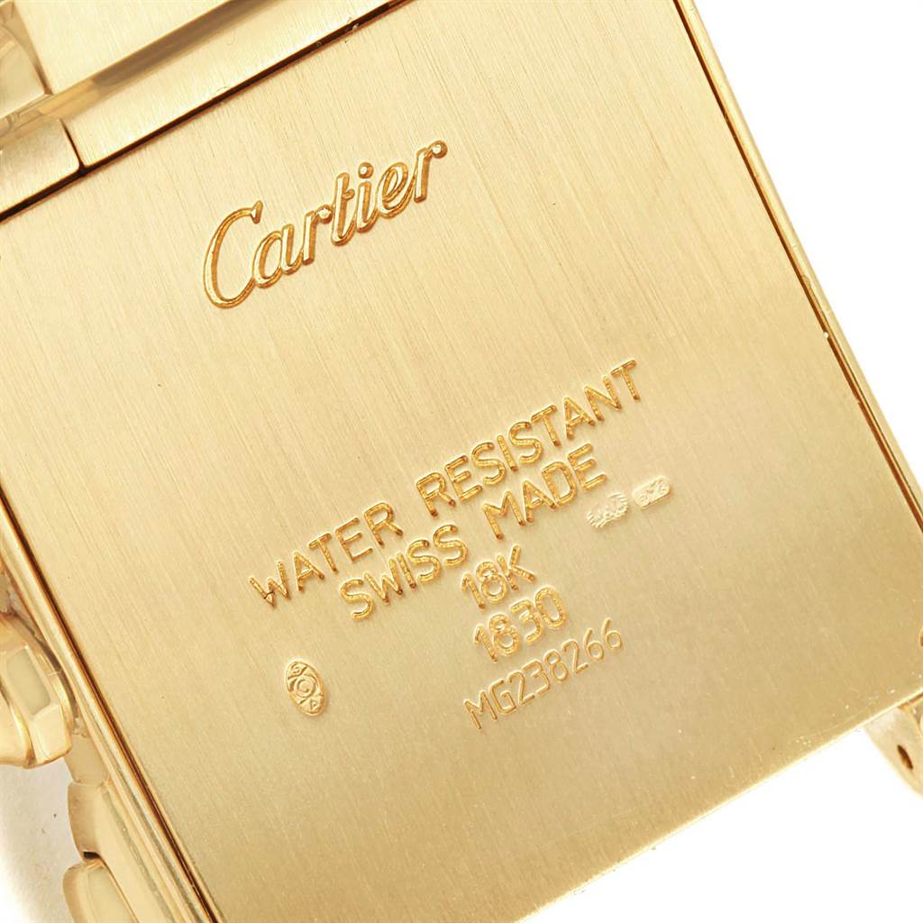 The image shows a close-up of the back case, marked with "Cartier," of a gold Tank Francaise watch by Cartier.
