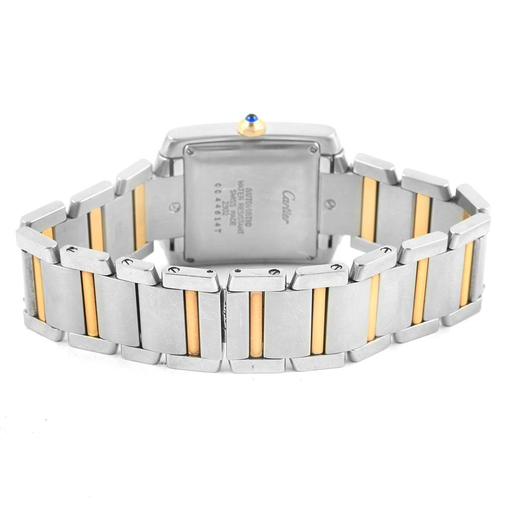 The Tank Française by Cartier is shown from the back, focusing on the case back, bracelet, and crown.