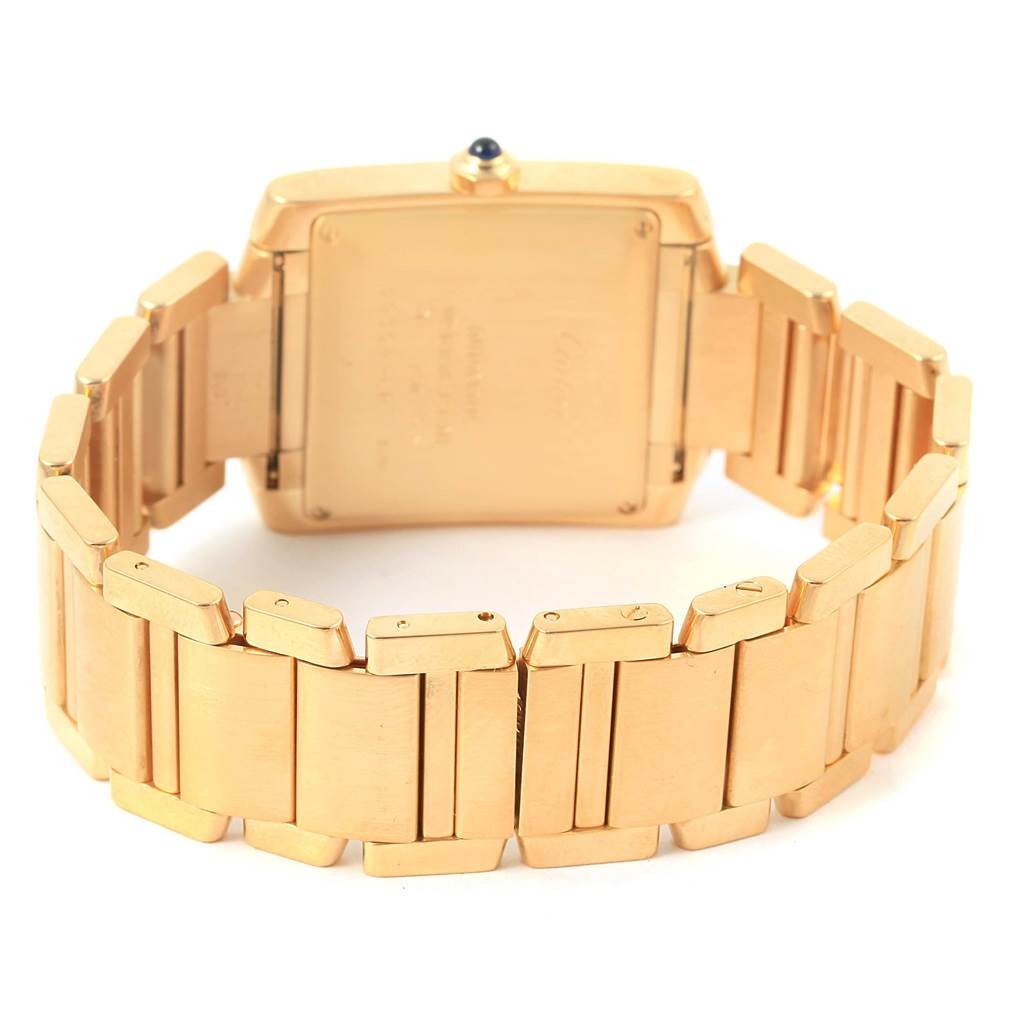 The image shows the back view of a Cartier Tank Francaise W50001R2 Men's Yellow Gold Silver Dial W50001R2 Men's Yellow Gold Silver Dial watch, focusing on its gold case and bracelet links.