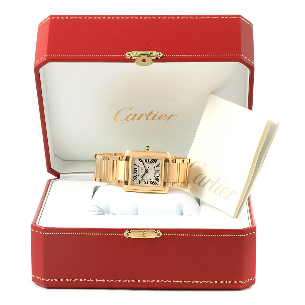 The Cartier Tank Francaise W50001R2 Men's Yellow Gold Silver Dial W50001R2 Men's Yellow Gold Silver Dial watch is displayed frontally in an open red Cartier box with its booklet.
