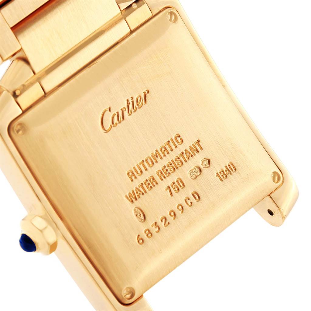 The image shows the back case and part of the bracelet of the Cartier Tank Française watch, highlighting its engravings.