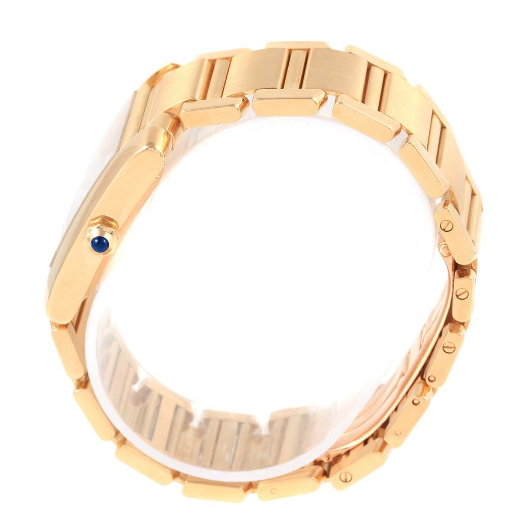The image shows a Cartier Tank Francaise W50001R2 Men's Yellow Gold Silver Dial W50001R2 Men's Yellow Gold Silver Dial watch from the side, focusing on its gold bracelet and crown with a blue cabochon.