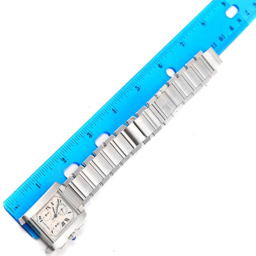 The image shows a Cartier Tank Francaise W51001Q3 Men's Stainless Steel White Dial W51001Q3 Men's Stainless Steel White Dial watch laid flat with its metal bracelet, next to a blue ruler for scale.