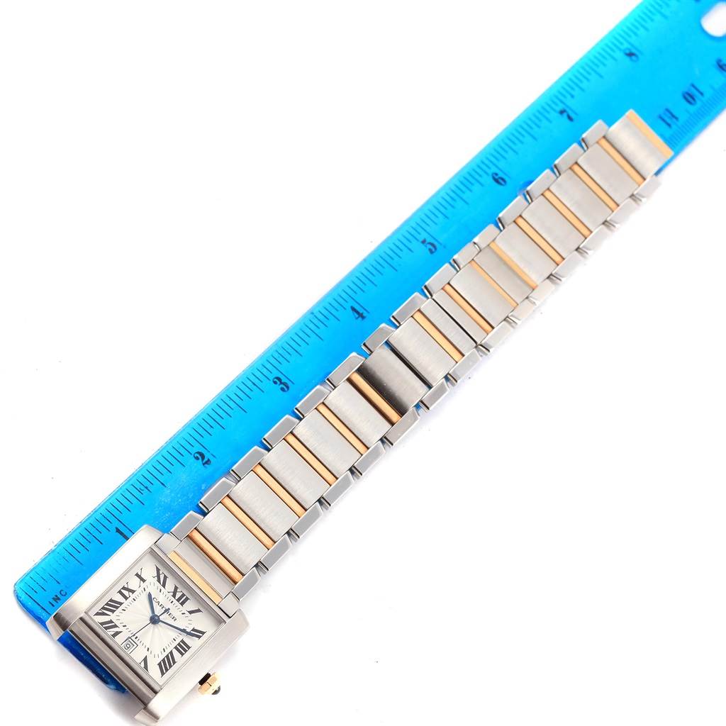 The image shows a top-down view of a Cartier Tank Francaise W51005Q4 Men's Steel and Gold (two tone) Silver Dial W51005Q4 Men's Steel and Gold (two tone) Silver Dial watch with a ruler next to its bracelet for measurement.