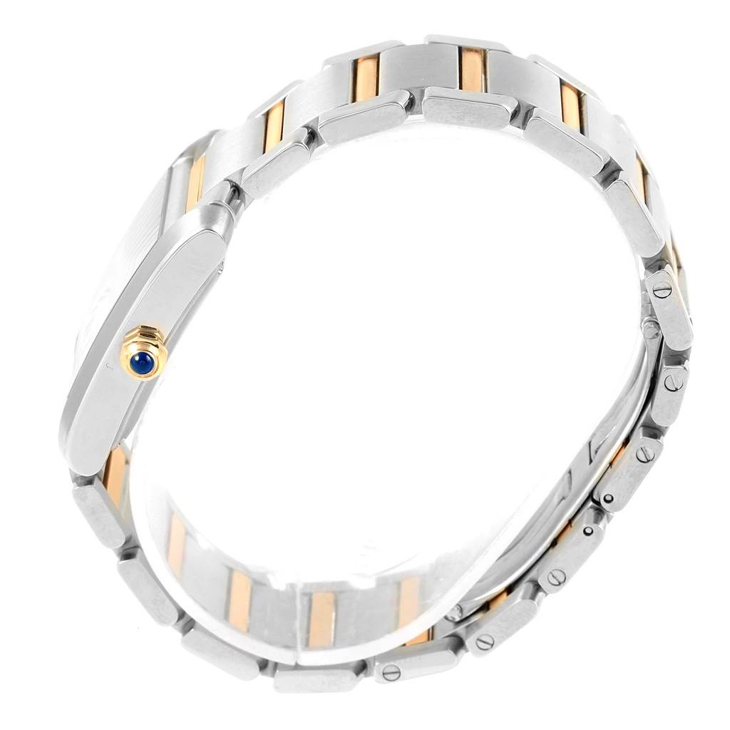This image shows the side profile of a Cartier Tank Francaise W51005Q4 Men's Steel and Gold (two tone) Silver Dial W51005Q4 Men's Steel and Gold (two tone) Silver Dial watch, focusing on its bracelet and crown with a blue gemstone.