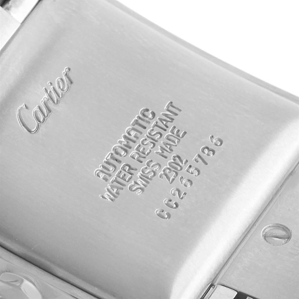 The image shows the back case of a Cartier Tank Française watch, featuring engravings and part of the clasp.