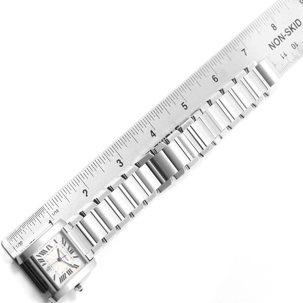 This image shows the Cartier Tank Francaise W51002Q3 Men
s Stainless Steel Silver Dial W51002Q3 Men
s Stainless Steel Silver Dial watch laid out alongside a ruler, highlighting its bracelet and watch face.