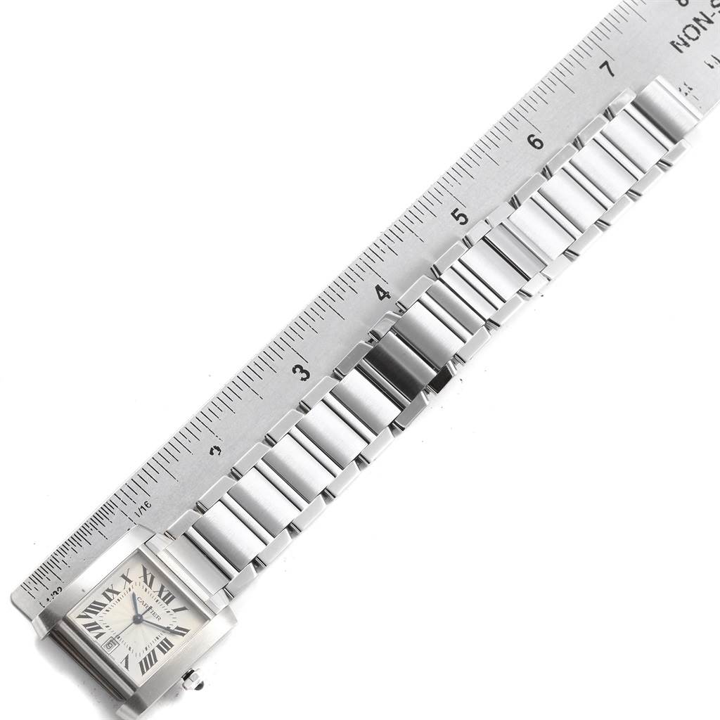 The image shows a Cartier Tank Francaise W51002Q3 Men's Stainless Steel Silver Dial W51002Q3 Men's Stainless Steel Silver Dial watch with its stainless steel bracelet laid alongside a ruler for measurement.