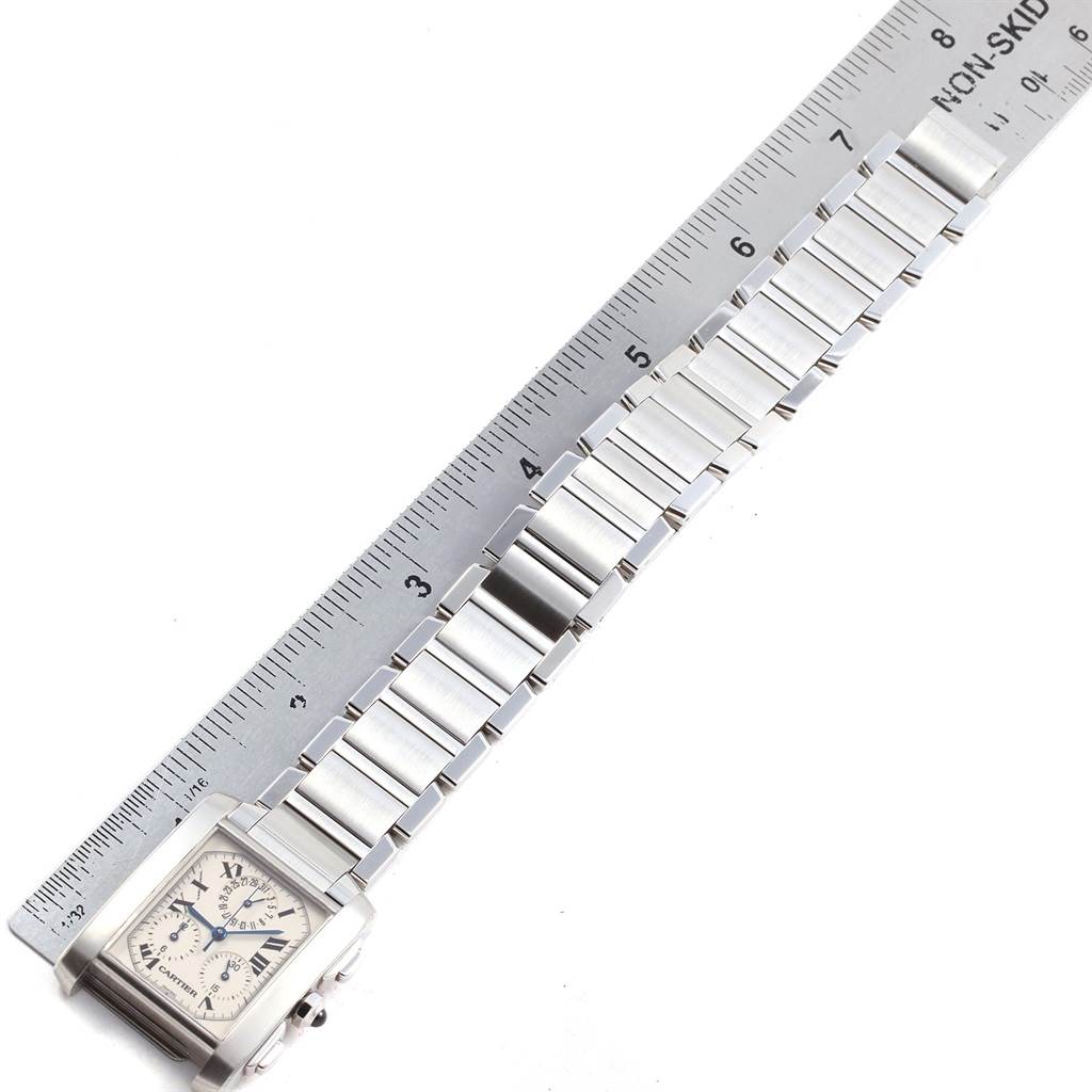 The image shows a side view of the Cartier Tank Francaise W51001Q3 Men
s Stainless Steel White Dial W51001Q3 Men
s Stainless Steel White Dial watch with its stainless steel bracelet aligned next to a ruler.
