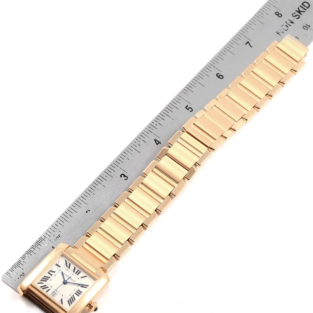 The image shows a Cartier Tank Francaise W50001R2 Yellow Gold Silver Dial W50001R2 Yellow Gold Silver Dial watch placed next to a ruler, highlighting its bracelet and rectangular face.