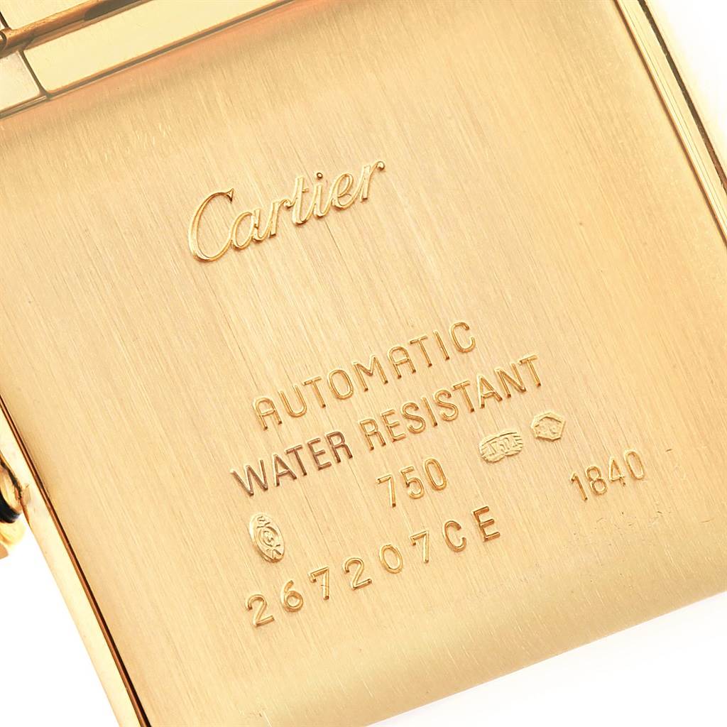 This image shows a close-up of the back casing of a Cartier Tank Française watch, showing engravings and hallmarks.