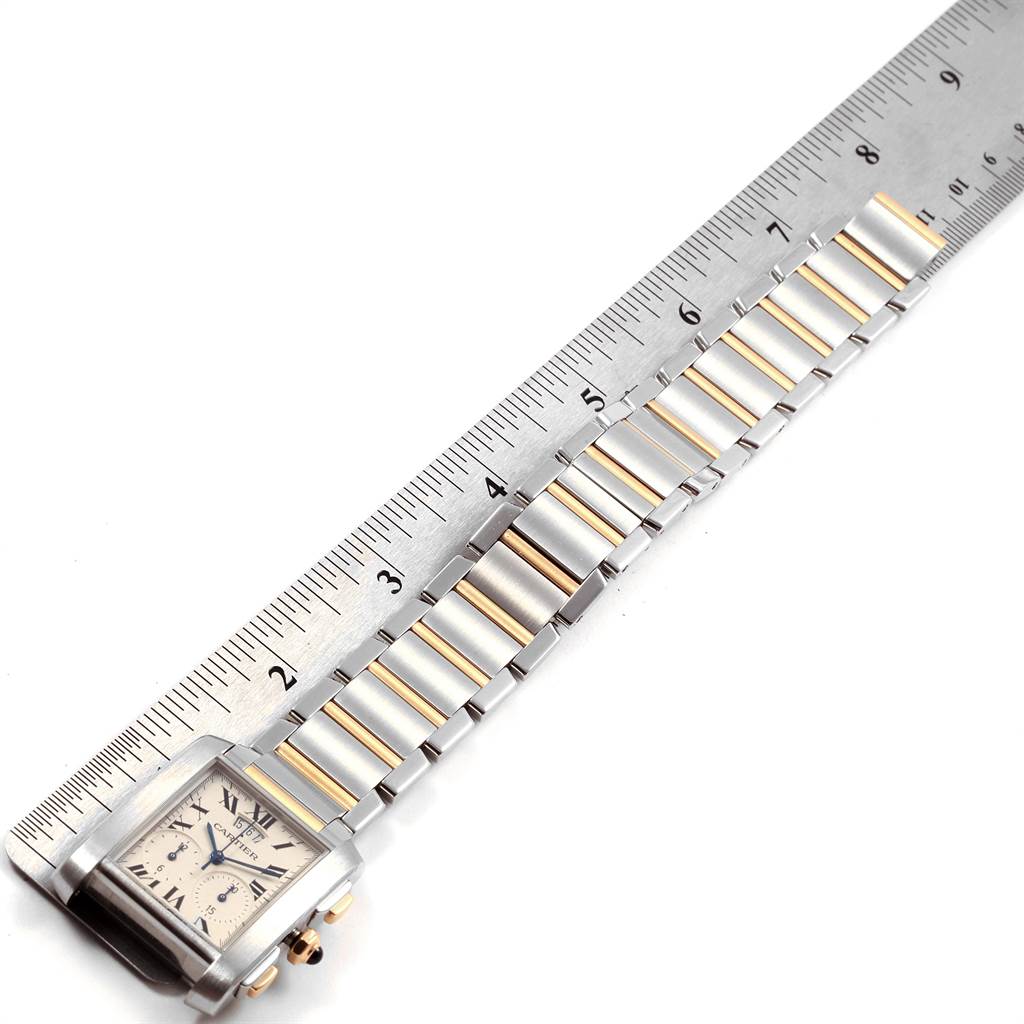 The image shows a Cartier Tank Francaise W51004Q4 Men
s Steel and Gold (two tone) Silver Dial W51004Q4 Men
s Steel and Gold (two tone) Silver Dial watch placed flat with its bracelet extended alongside a ruler.