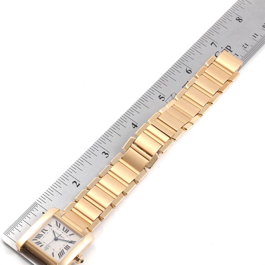 The image shows a Cartier Tank Francaise W50001R2 Yellow Gold Silver Dial W50001R2 Yellow Gold Silver Dial watch laid flat, with the face and metal bracelet visible next to a ruler for size reference.
