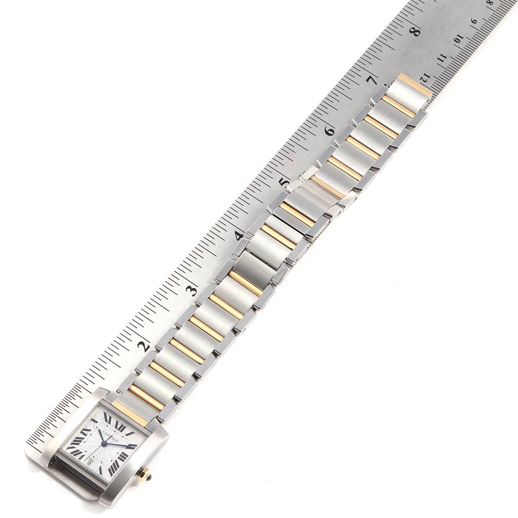 The image shows a Cartier Tank Francaise W51005Q4 Men's Steel and Gold (two tone) Silver Dial W51005Q4 Men's Steel and Gold (two tone) Silver Dial watch laid flat alongside a ruler, displaying the watch face and bracelet links.