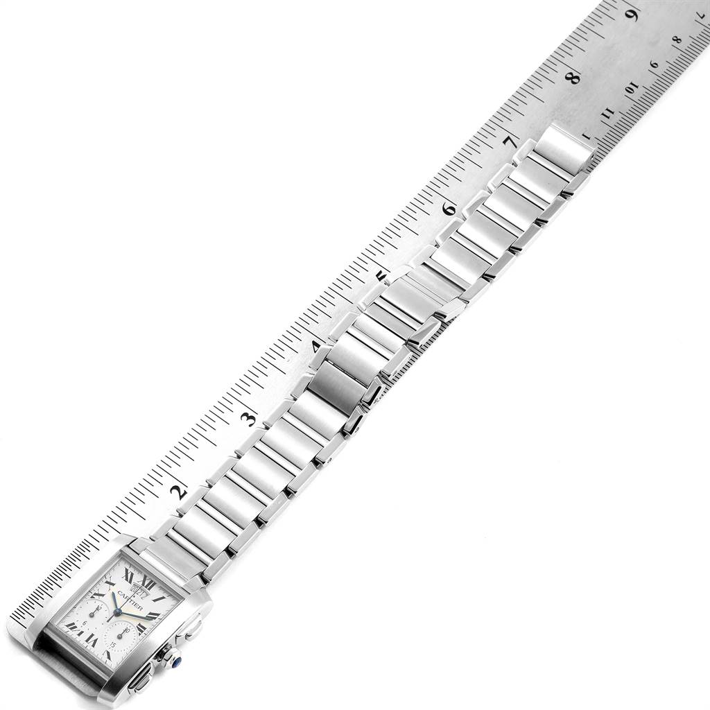 The Cartier Tank Francaise W51024Q3 Men's Stainless Steel Silver Dial W51024Q3 Men's Stainless Steel Silver Dial watch is shown in a top-down angle, displaying its face, bracelet, and part of a ruler for measurement.