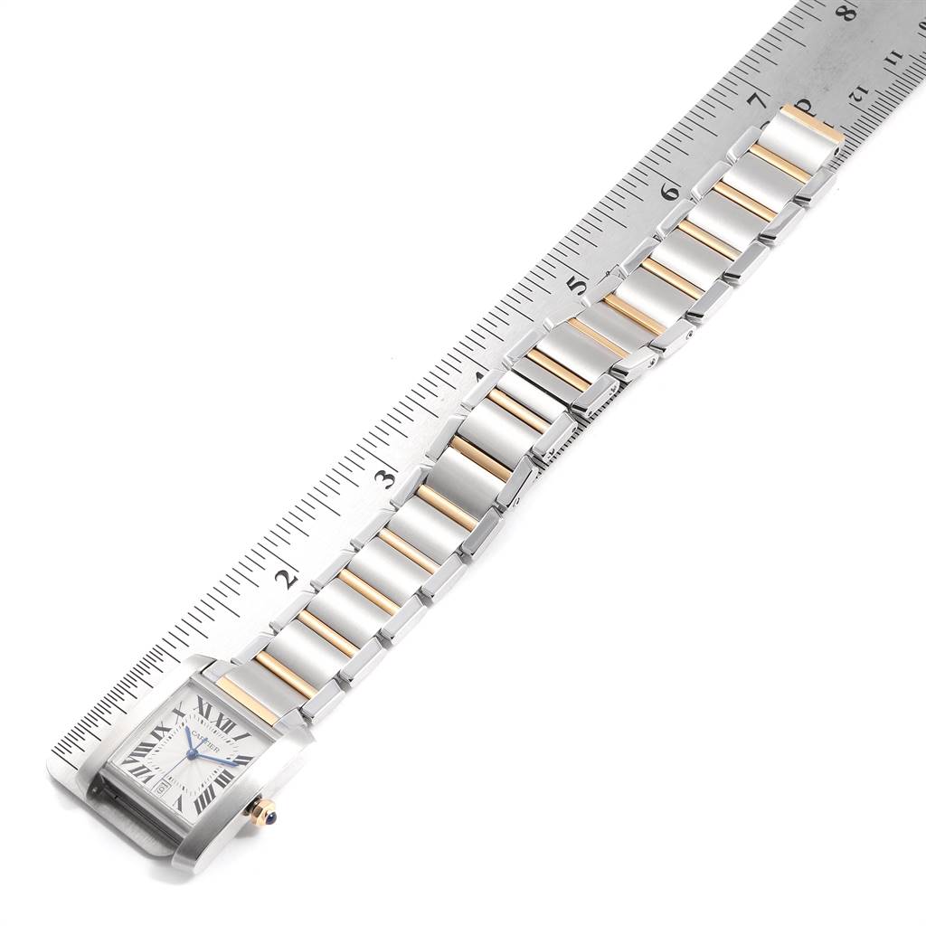 The Cartier Tank Francaise W51005Q4 Men's Steel and Gold (two tone) Silver Dial W51005Q4 Men's Steel and Gold (two tone) Silver Dial watch is shown from a top-down angle with its face and band aligned next to a ruler for measurement.